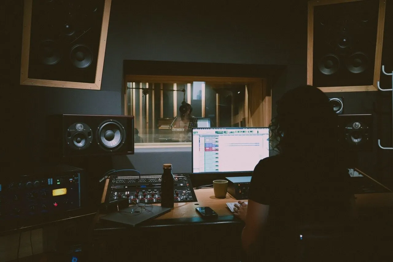 A sound engineer working in the control room of a recording studio
